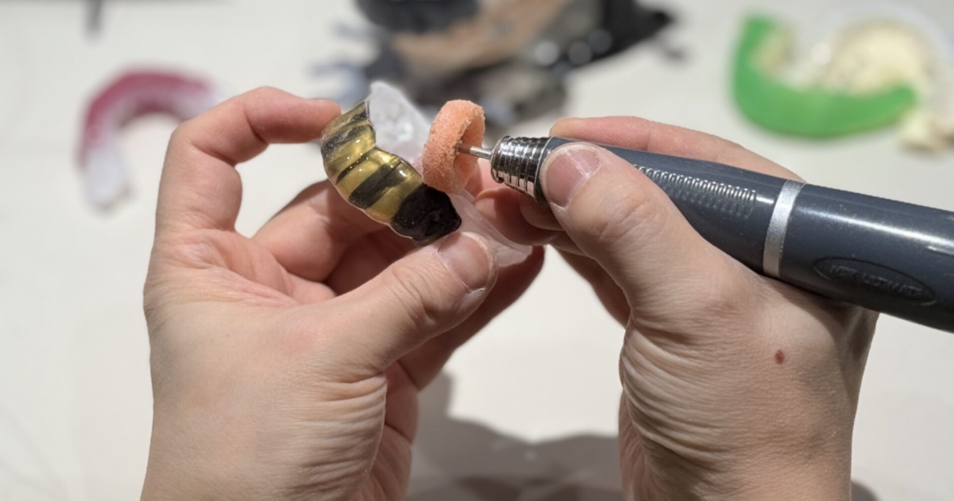 歯科技工士が研磨器を使ってカスタムメイドマウスガードを仕上げている様子